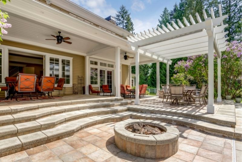A white pergola attached to the house